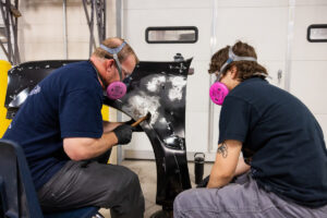 A student working on car parts with an instructor during class at Crockett high school (ACC South Austin campus.)