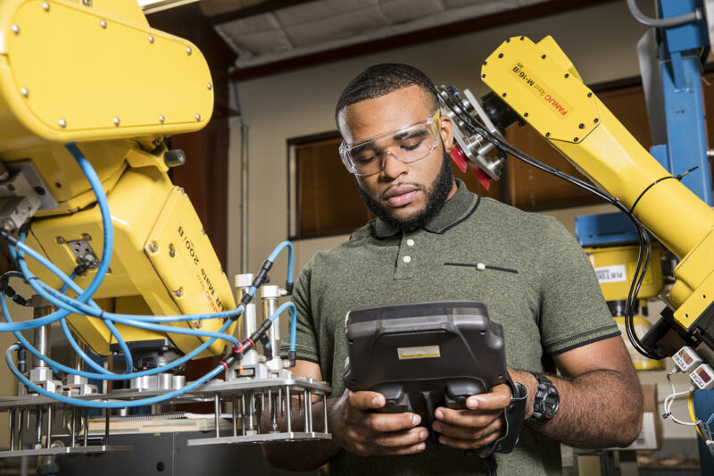 ACC student with equipment from the Electronics and Advanced Technologies department at the Riverside campus