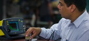 Student Pedro Villarreal uses ultrasonic testing equipment to detect flaws.